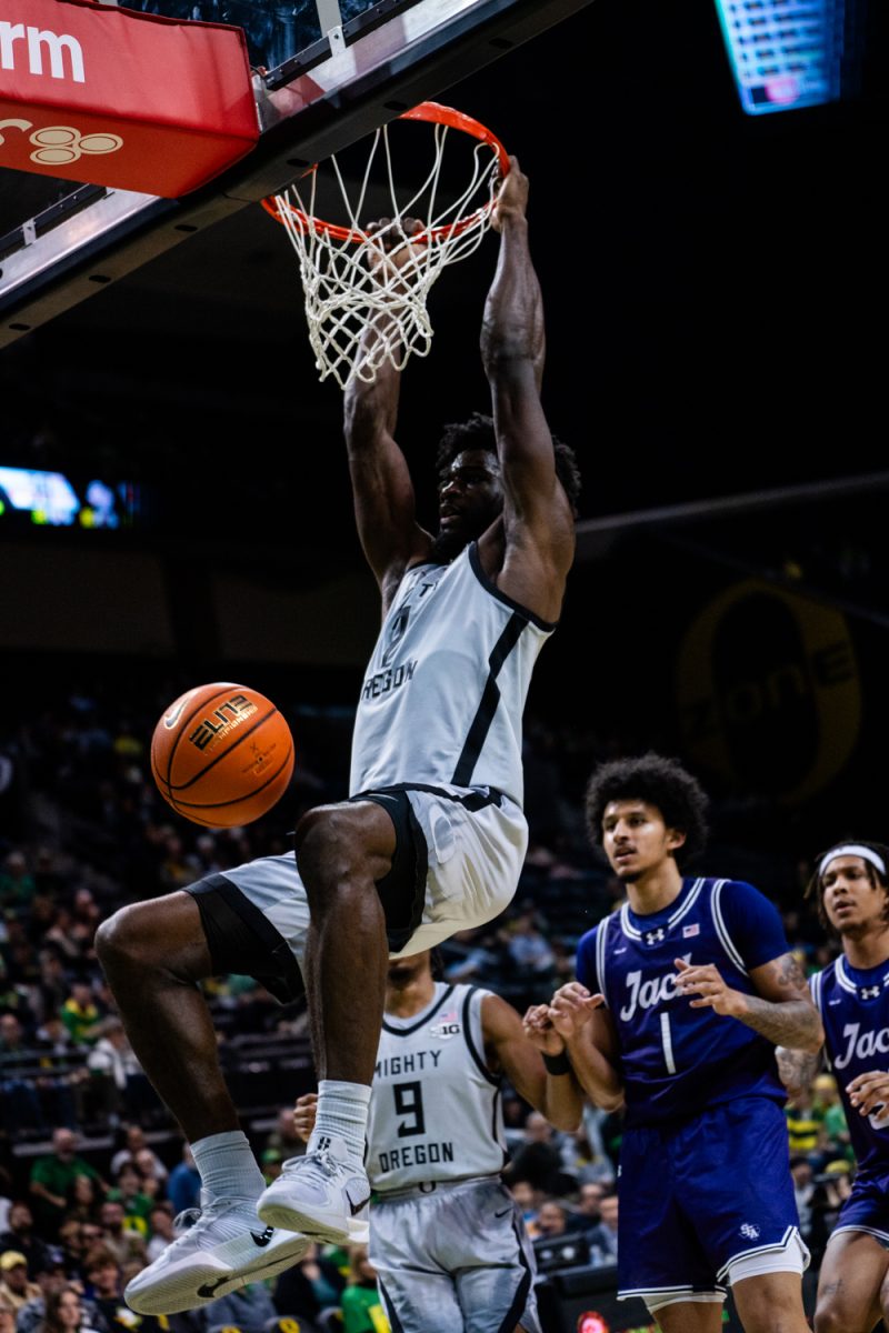 Supreme Cook (7) dunking the ball. The University of Oregon Ducks Mens Basketball team defeat the SFA Lumberjacks (79-61) in a home match at Matthew Knight Arena in Eugene, Ore., on Dec. 15, 2024. (Rowan Campbell/Emerald).