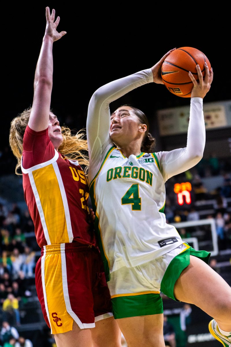 Nani Falatea (4) plays hard to get ball in basket despite Avery Howell's (23) defense. The University of Oregon Ducks Women's Basketball team lose to the University of Southern California Trojans (53-66) in a home match at Matthew Knight Arena in Eugene, Ore., on Dec. 7, 2024. (Rowan Campbell/Emerald).