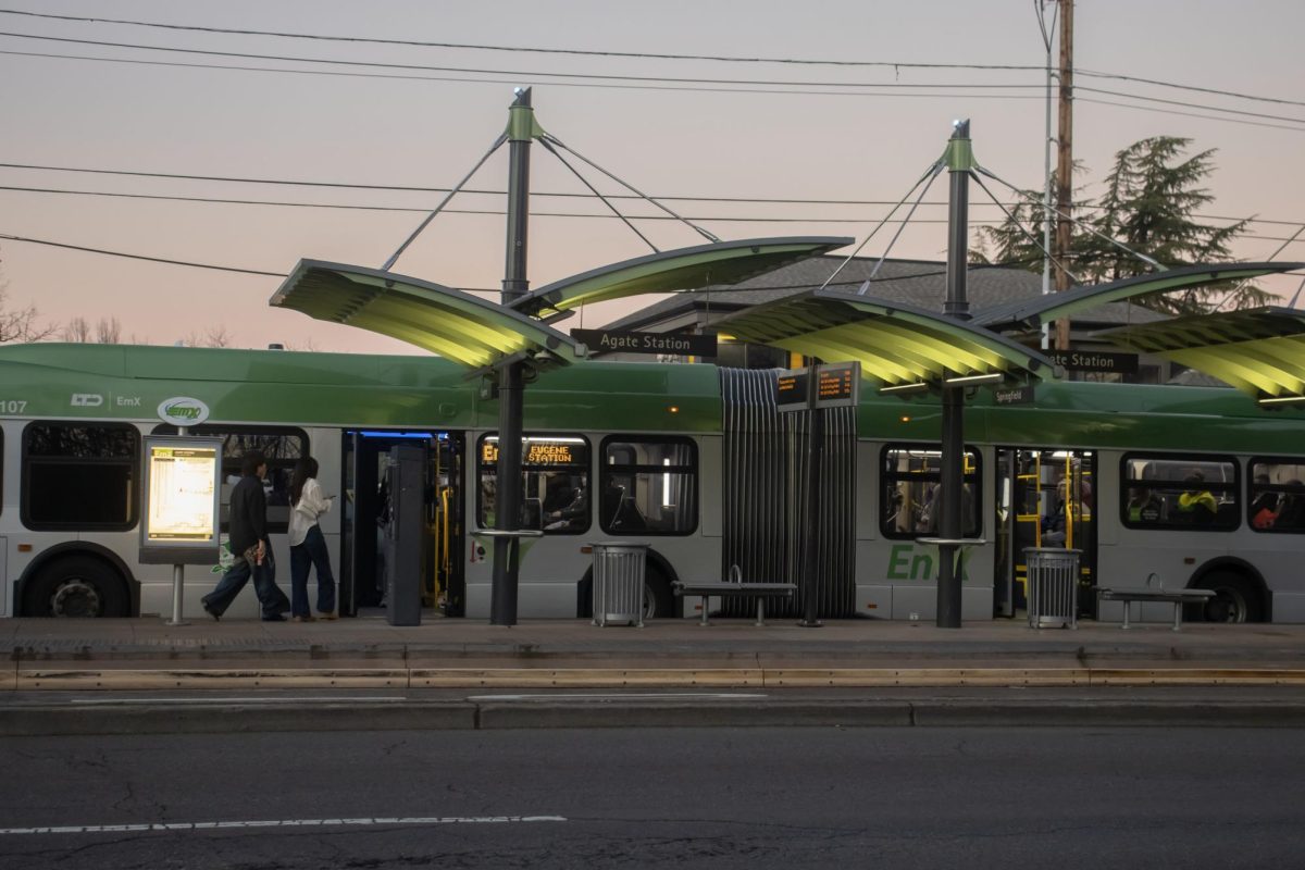 Two passengers enter the EMX bus at the Agate Station in Eugene, Ore. (Alyssa Garcia/Emerald) 
