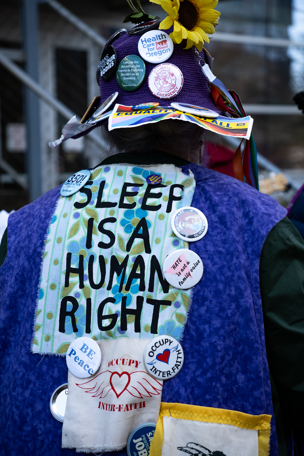 The Raging Grannies, a group of grandmothers from Eugene, Ore. who sing to promote social and economic equality attending the "We Fight Back" rally, adorned with signage and pins supporting their cause. (Saj Sundaram/Emerald)