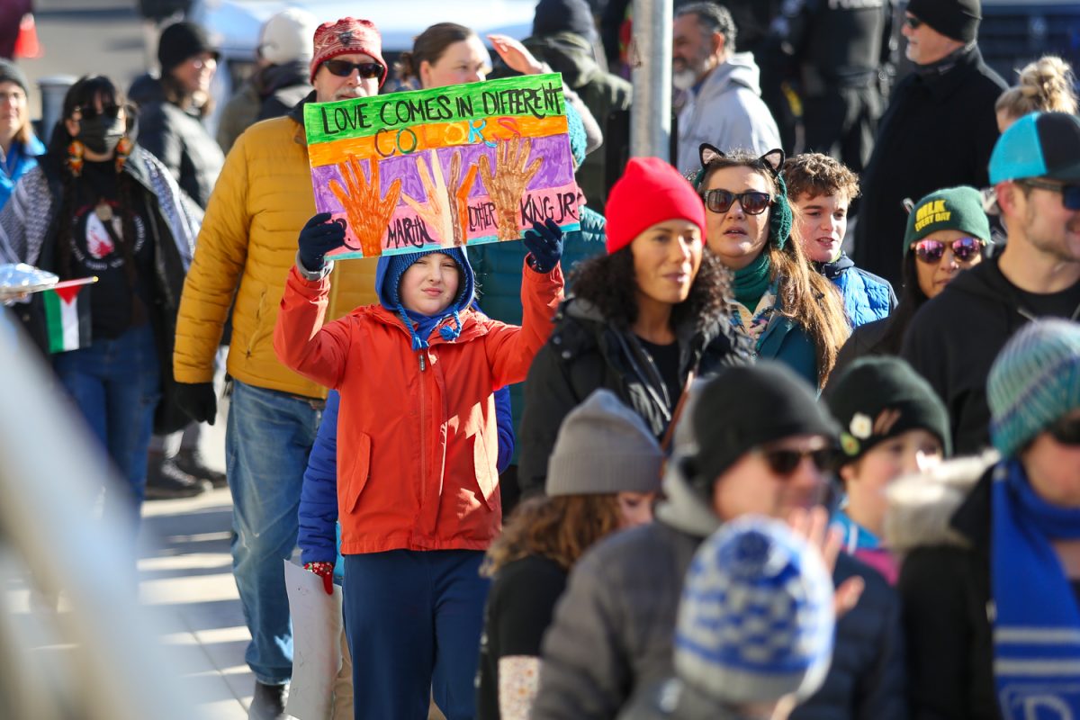 Child holds up a sign at the end of the MLK Day March. MLK Day Marchers walk through Downtown Eugene, Ore. on Jan 20, 2025 (Tyler Graham/Emerald)