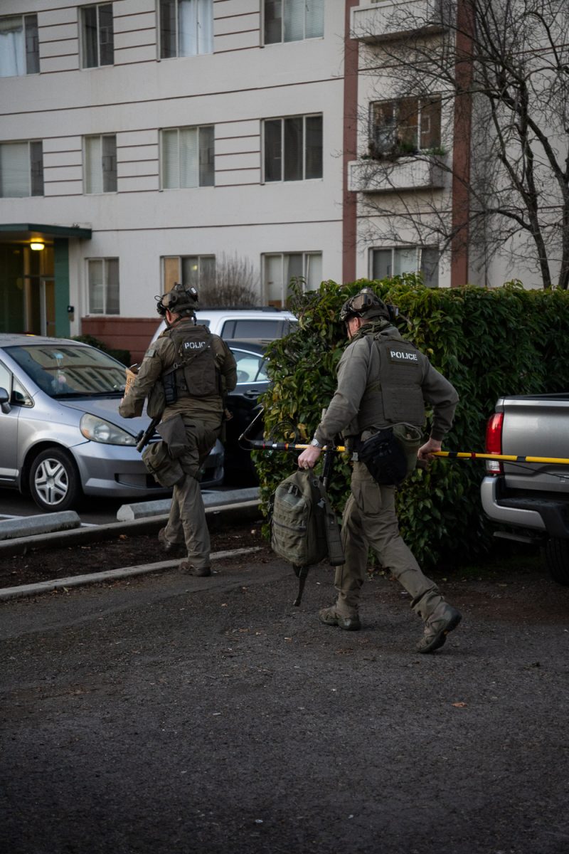 Heavily armed police prepare their gear and themselves to go inside the building where a suspect as barricaded themselves on the sixth floor. (Saj Sundaram/Emerald)