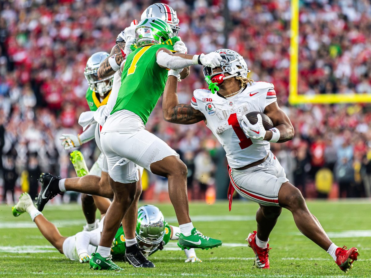 Oregon defensive back Jabbar Muhammad (7) grabs the facemask of Ohio State running back Quinshon Judkins (1), resulting in a 15-yard penalty. The University of Oregon Ducks Football team played the Ohio State University Buckeyes in the Rose Bowl at Rose Bowl Stadium in Pasadena, Calif., on Jan. 1, 2025, where they lost 41-21. (Max Unkrich/Emerald)