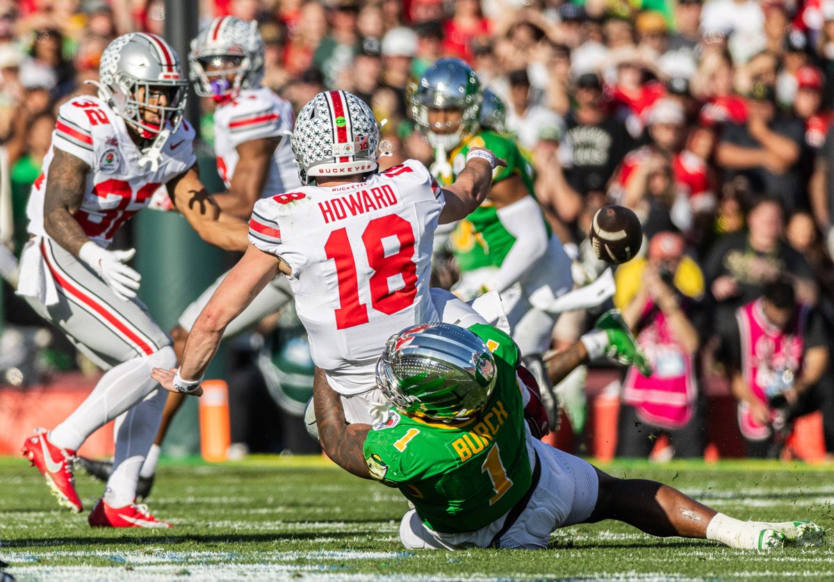 Oregon defensive end Jordan Burch (1) attempts to sack Ohio State quarterback Will Howard (18) as Howard throws the ball away. Despite Burch’s efforts, Oregon recorded zero sacks in the game, while Ohio State recorded eight. The University of Oregon Ducks Football team played the Ohio State University Buckeyes in the Rose Bowl at Rose Bowl Stadium in Pasadena, Calif., on Jan. 1, 2025, where they lost 41-21. (Max Unkrich/Emerald)