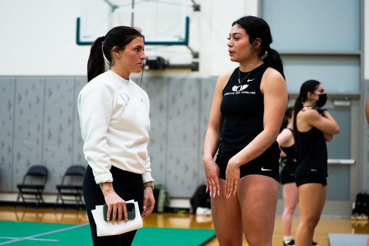 Molly Dahlager (56) talks with Jacie Van de Zilver (AC). The University of Oregon Ducks Acrobatics and Tumbling team practices at Matthew Knight Arena in Eugene, Ore., on Feb. 6, 2025. (Rowan Campbell/Emerald).