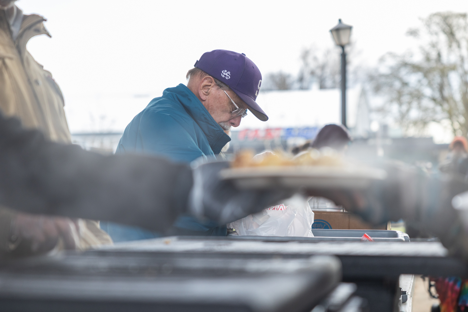 Pat Reilly mans his station as plates of food are handed out. Volunteers with Neighbors feeding Neighbors hand out food and drinks at 5th and Washington Wednesday-Saturday starting at 9am. (Molly McPherson/Emerald)