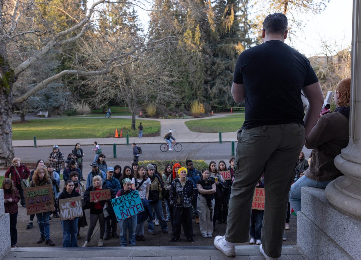 Ryan Campbell, a member of the bargaining team of the University of Oregon Student Workers Union, speaks to the crowd of union members and supporters gathered outside Johnson Hall. (Miles Cull/Emerald)