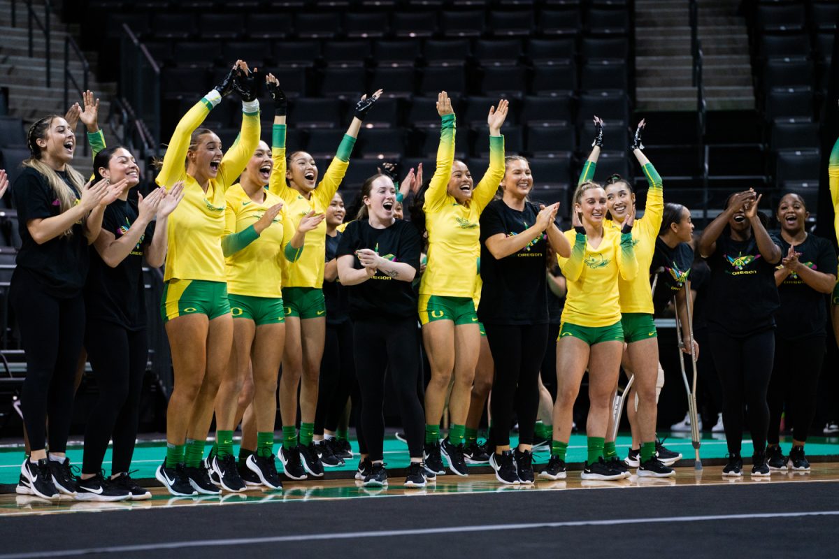 Oregon sideline chearing during the routine. The University of Oregon Ducks Women’s Acrobatics and Tumbling team in a home match against Morgan State at Matthew Knight Arena in Eugene, Ore., on Feb. 15, 2025. (Rowan Campbell/Emerald).