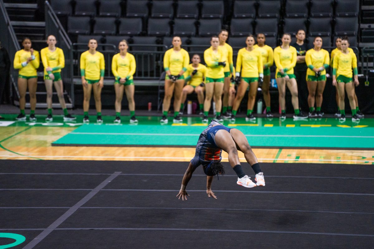 Oregon Acro watches as Kayla Bryant (23) tumbles infront of them. The University of Oregon Ducks Women’s Acrobatics and Tumbling team in a home match against Morgan State at Matthew Knight Arena in Eugene, Ore., on Feb. 15, 2025. (Rowan Campbell/Emerald).