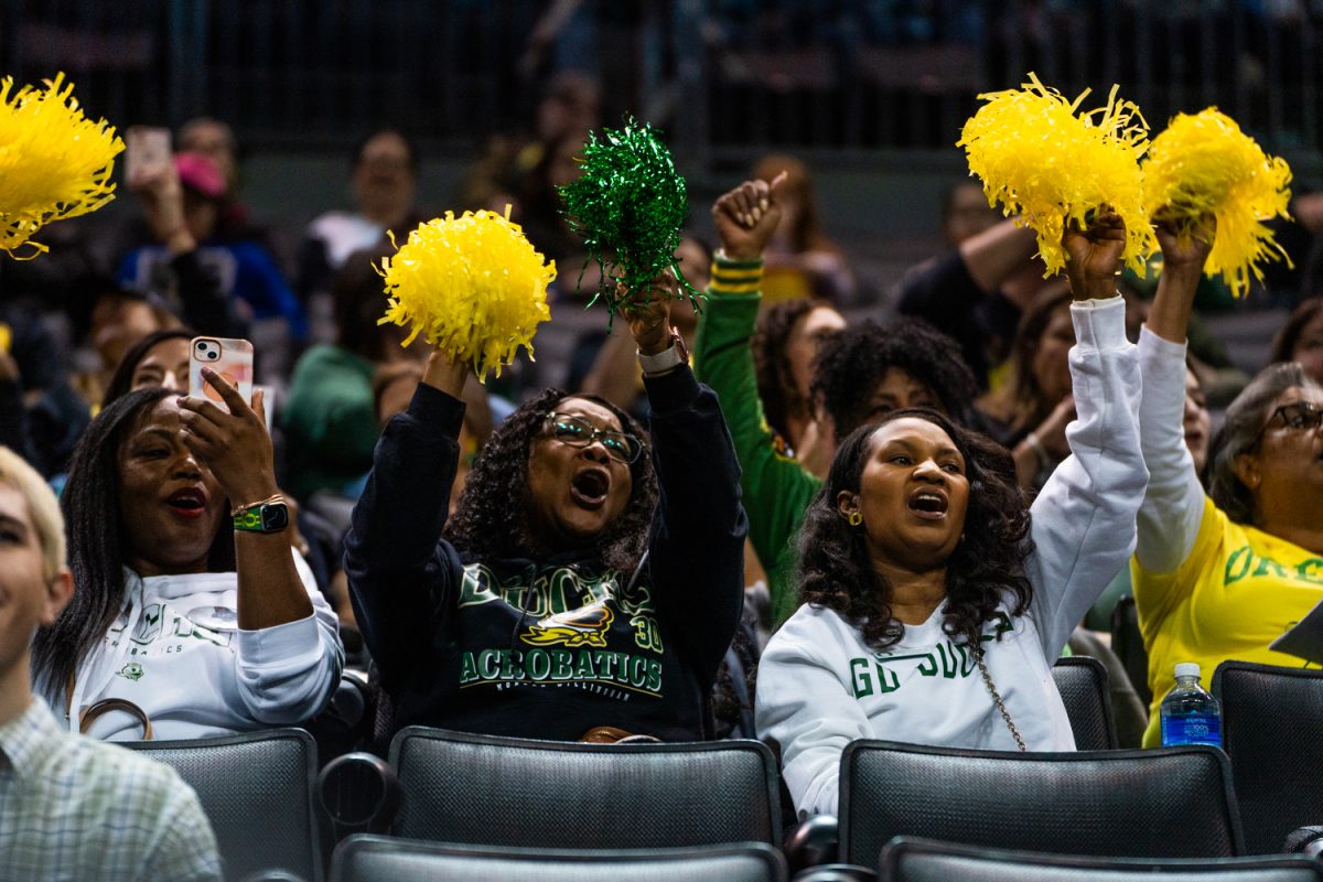 Fans wave poms at the introduction to teams before competition. The University of Oregon Ducks Women’s Acrobatics and Tumbling team in a home match against Morgan State at Matthew Knight Arena in Eugene, Ore., on Feb. 15, 2025. (Rowan Campbell/Emerald).