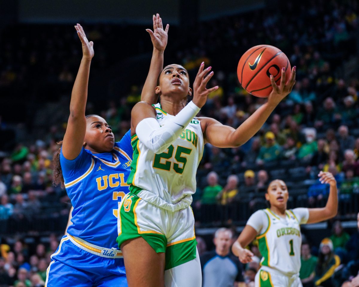 Deja Kelly (25) jumps through Timea Gardiner (30) for a layup. The University of Oregon Ducks Women’s Basketball team lose to the UCLA Bruins (62-52) in a home match at Matthew Knight Arena in Eugene, Ore., on Feb. 9, 2025. (Rowan Campbell/Emerald).