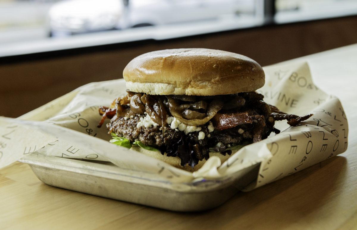 Willamette Burger from Bo & Vine with goat cheese crumbles, smoked bacon, housemade sweet chili sauce, caramelized onion, balsamic reduction, and spring mix lettuce. (Max Unkrich/Emerald)