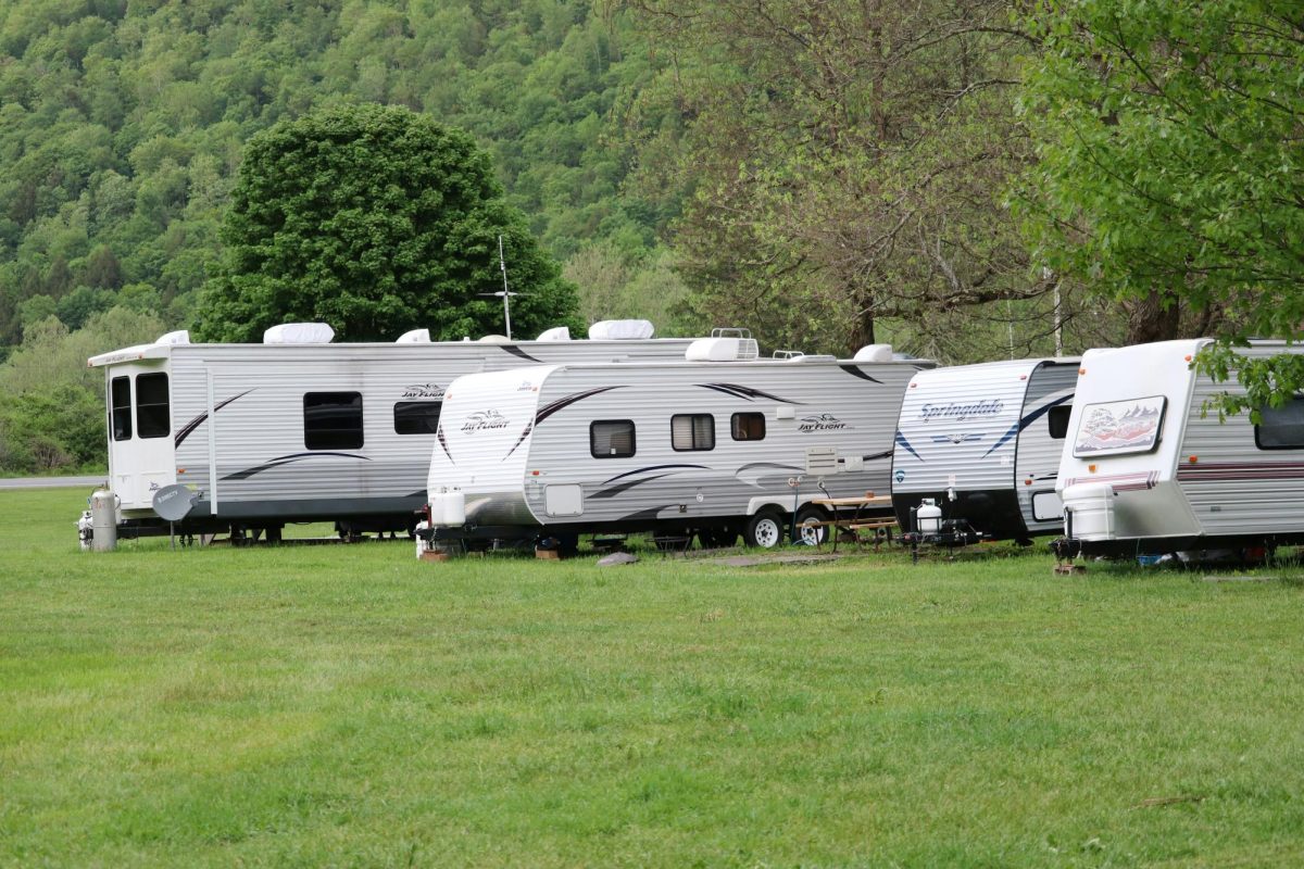 https://unsplash.com/photos/white-and-brown-rv-trailer-on-green-grass-field-during-daytime-SWuFxMb8Y8w