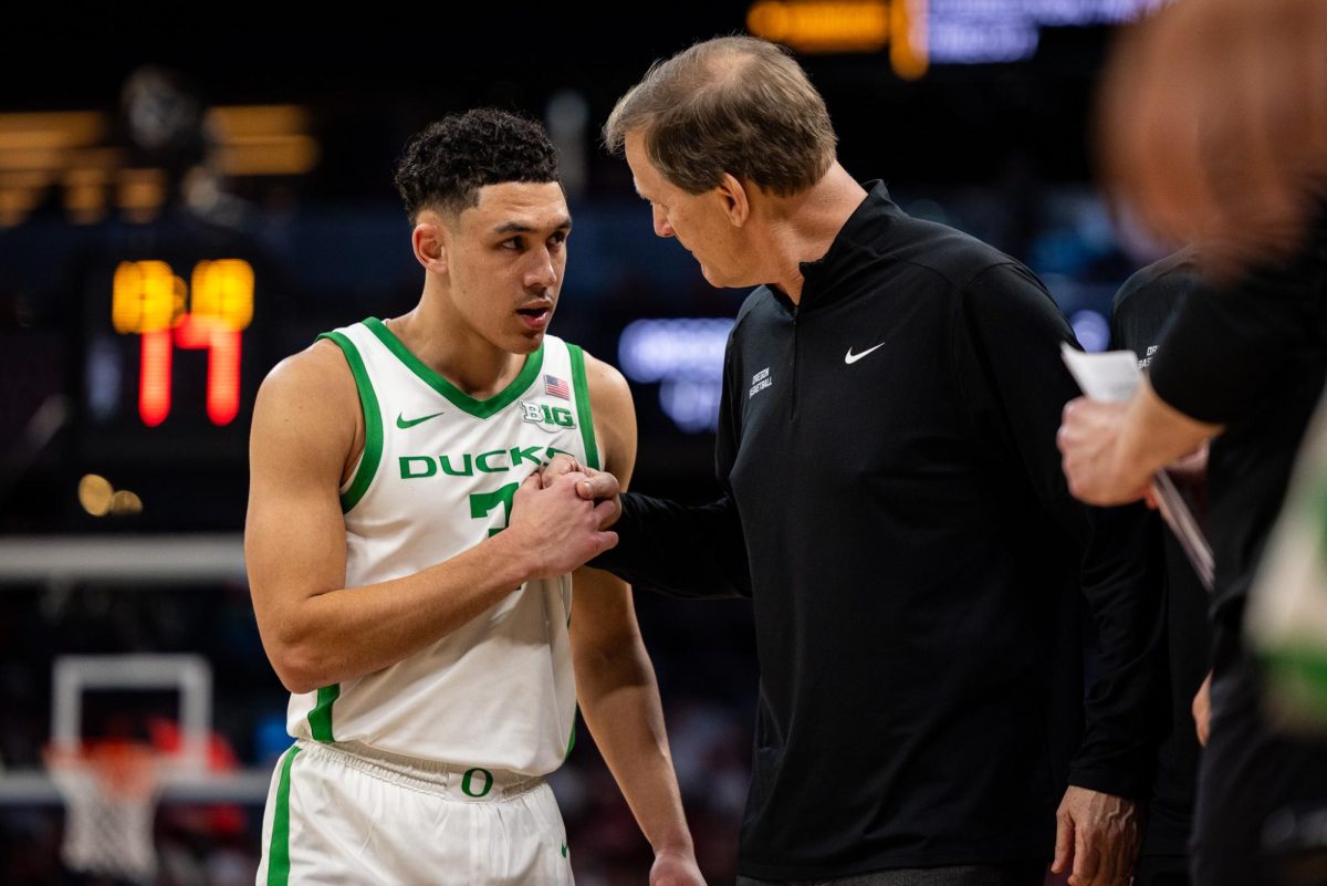 Head coach, Dana Altman, talks to his young star early in the match. The Oregon Ducks take on the Indiana Hoosiers in the second round of the Big Ten Tournament at Gainbridge Fieldhouse in Indianapolis, IN, on March 13, 2025. (Jonathan Suni/Emerald)