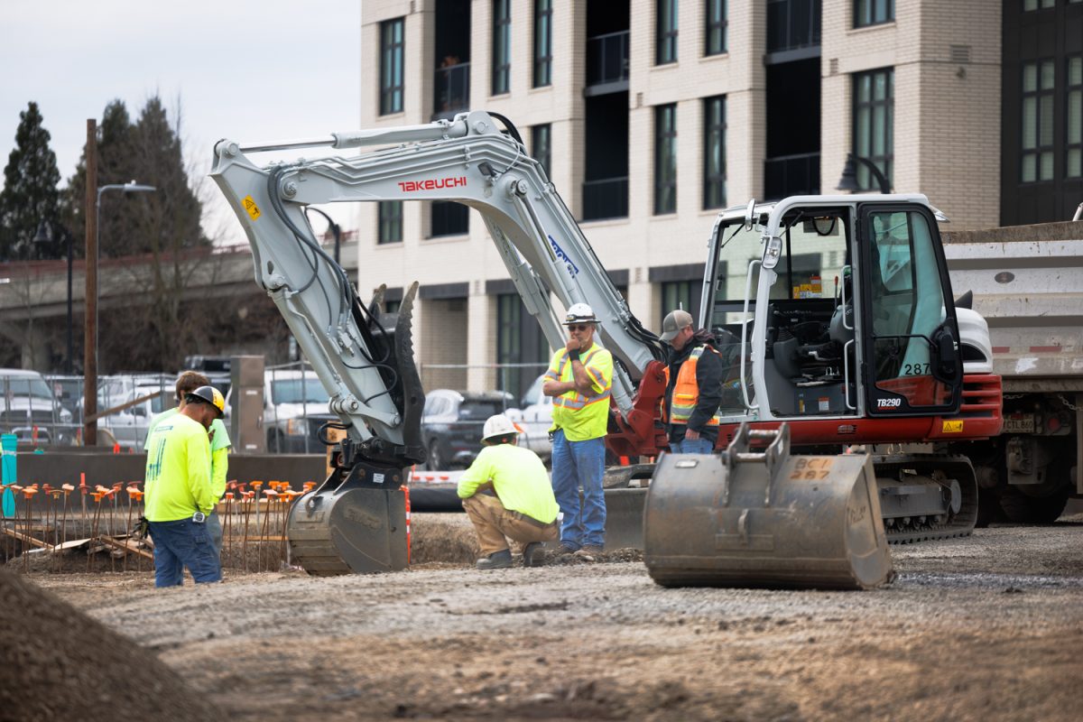 Contruction workers next to a excavator Mar.11.2025 at the River front construction site in downtown Eugene, Ore (Darby Winter/Emerald)