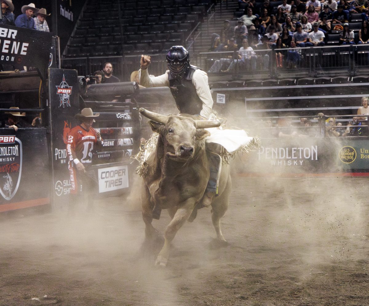Bob Mitchell, a 22-year-old cowboy, rides a bull at Matthew Knight Arena on April 5, 2025. Hundreds of tons of dirt covered the floor of MKA as cowboys and bulls visited Eugene for the Professional Bull Riders Pendleton Whisky Velocity Tour. (Alex Hernandez/Emerald)