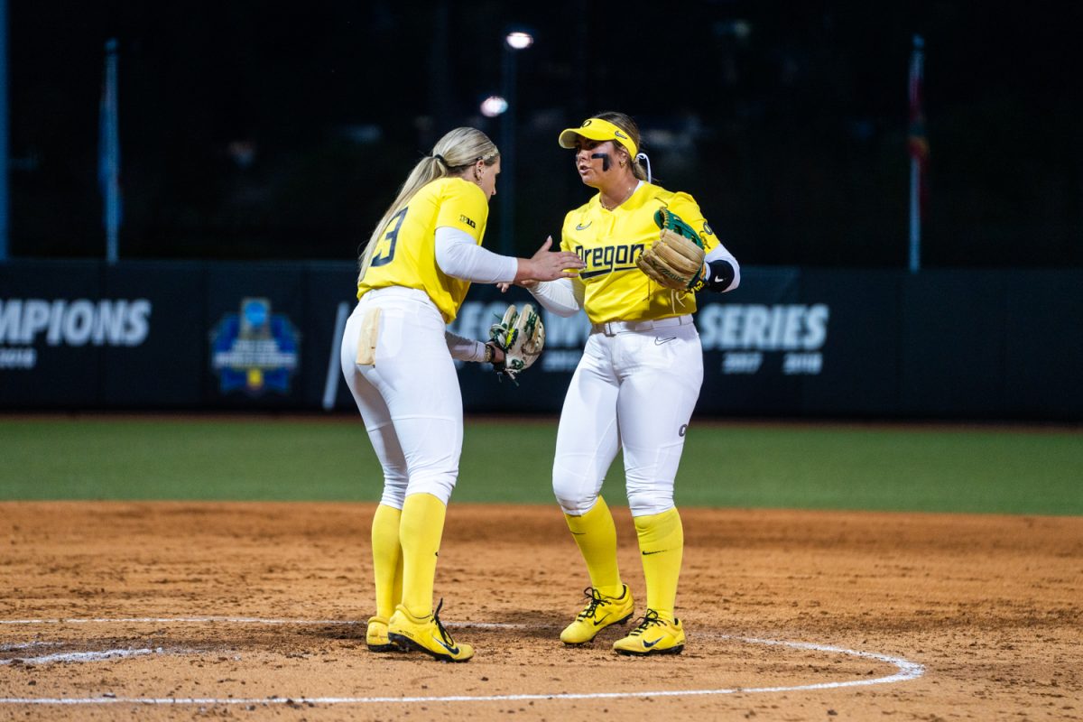 Oregon pitcher Lyndsey Grein (33) exchanges with infielder Rylee McCoy (24). The #5 ranked University of Oregon Ducks Women’s Softball team take on a home game against the #6 ranked UCLA Bruins in Eugene, Ore., on April. 18, 2025. (Rowan Campbell/Emerald).
