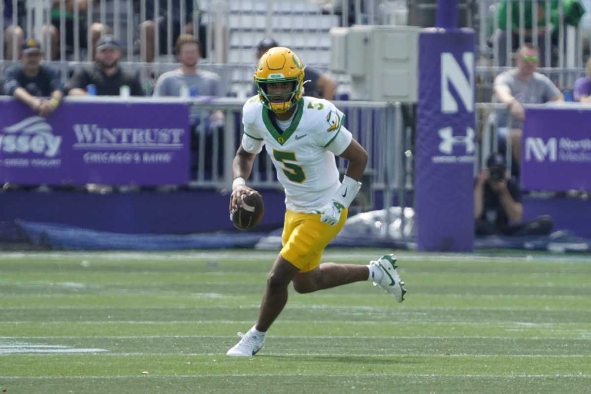 Sep 13, 2025; Evanston, Illinois, USA; Oregon Ducks quarterback Dante Moore (5) runs the ball past Northwestern Wildcats defensive lineman Anto Saka (4) during the first half at Northwestern Medicine Field at Martin Stadium. Mandatory Credit: David Banks-Imagn Images