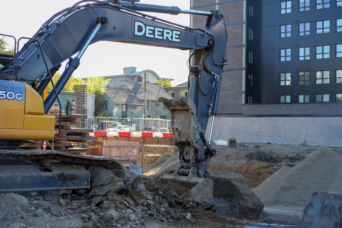 An excavator moves ground as construction continues on 13th and Alder in Eugene, Ore. (Tyler Graham/Emerald)
