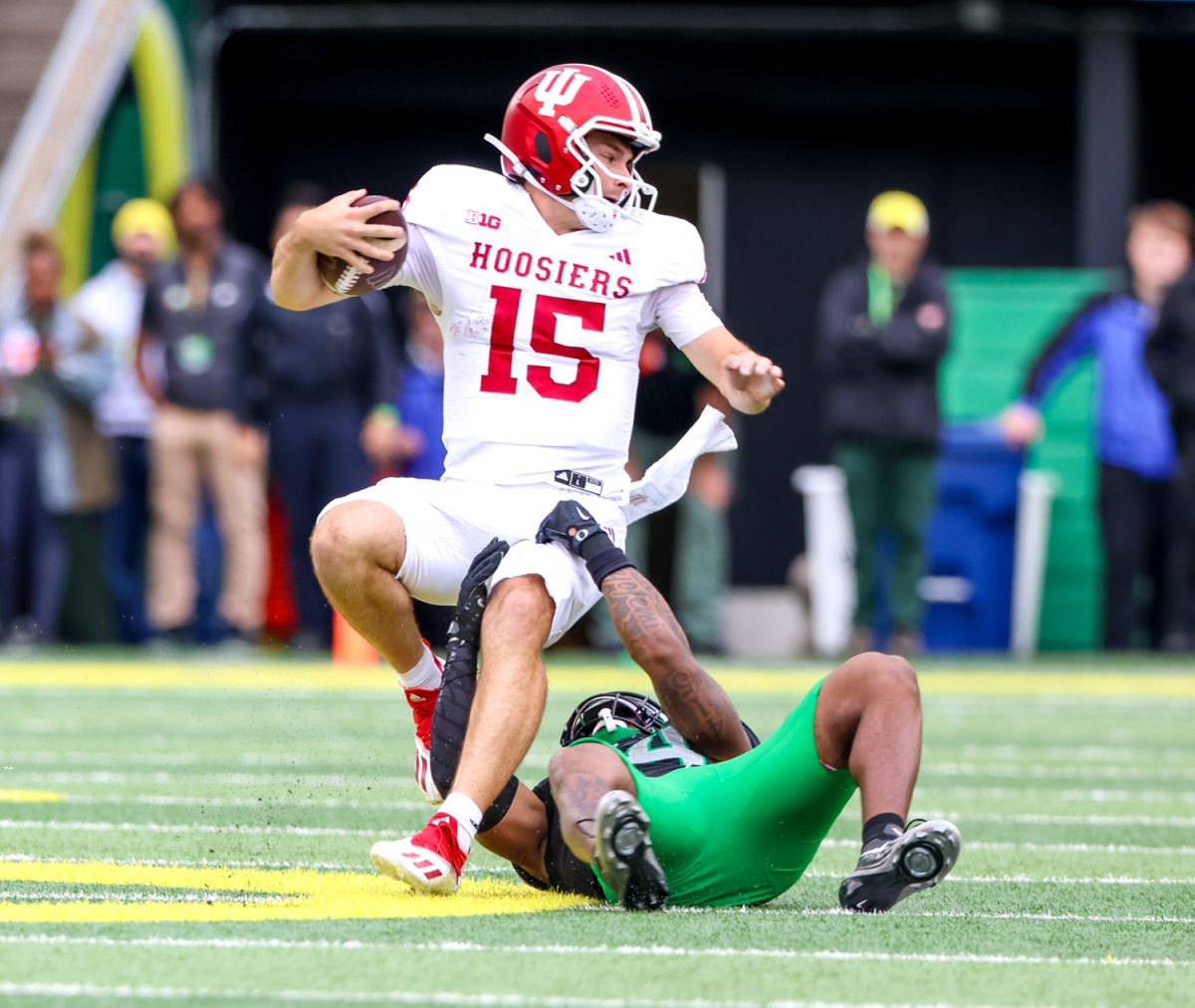 Oregon Ducks linebacker Jerry Mixon (54) tackles Indiana Hoosiers quarterback Fernando Mendoza (15). On October 11, 2025 the University of Oregon Ducks played the Indiana University Hoosiers at Autzen Stadium in Eugene, Ore. The Hoosiers defeated the Ducks 30-20. (Anna Liv Myklebust / Emerald)