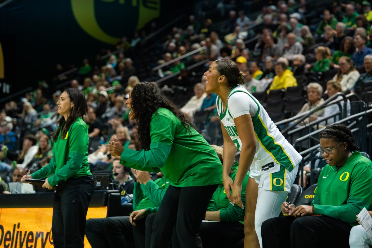 Oregon Duck Coach Jerise Freeman and player Avary Cain (42) cheer on the team. On Oct. 30, 2025 the Oregon Ducks played the Western Oregon Wolves at Matthew Knight Arena in Eugene, Ore. (Katie Poluyansky/Emerald)