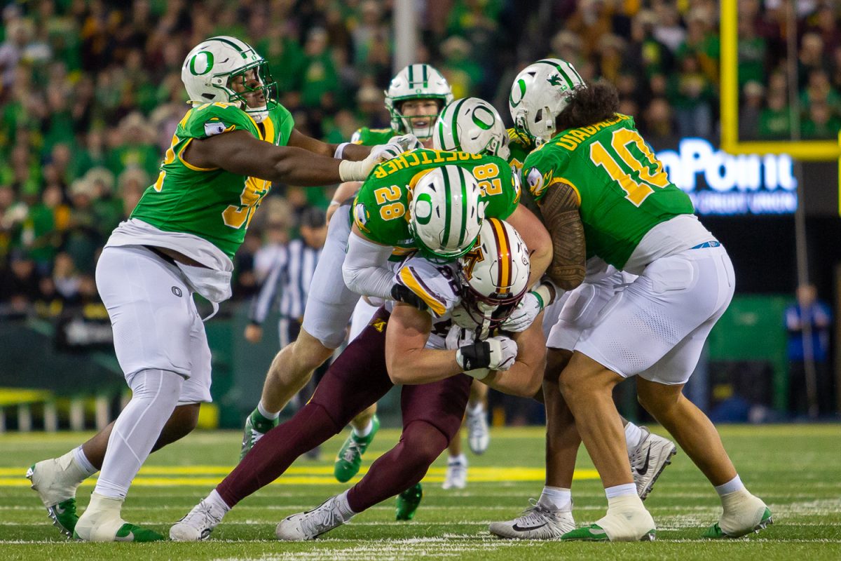 Oregon inside linebacker Bryce Boettcher (28) tackles Minnesota an offensive player. The University of Oregon Ducks host the University of Minnesota Gophers in a Friday night matchup on Nov. 14, 2025, at Autzen Stadium in Eugene, Ore. (Corey Hoffman/Emerald)