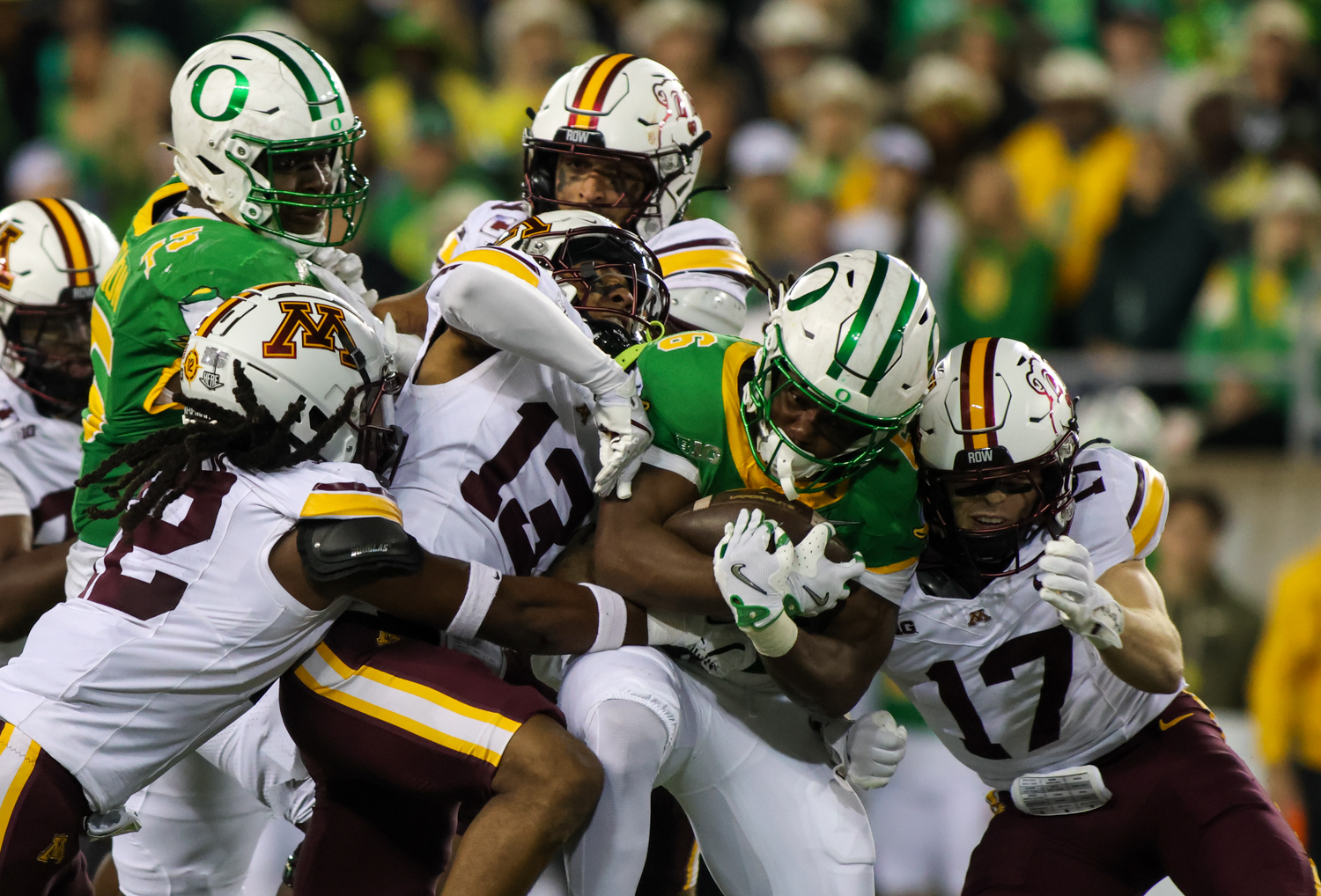 Running back for the Ducks, Noah Whittington (6), keeps hold of the ball as he is tackled by three Gophers. The University of Oregon Ducks host the University of Minnesota Gophers in a Friday night matchup on Nov. 14, 2025, at Autzen Stadium in Eugene, Ore. (Julia Massa/Emerald)