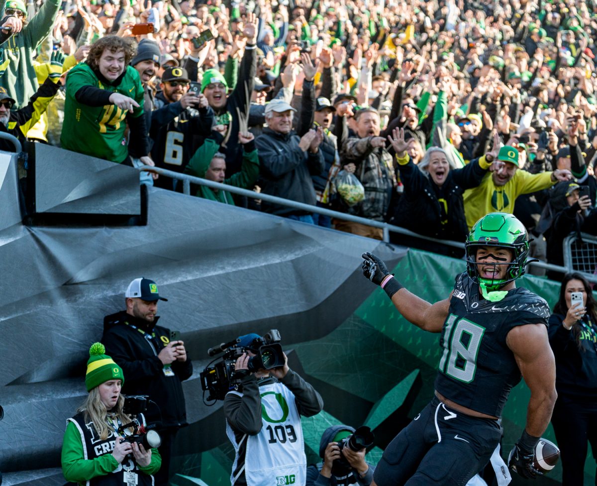 Oregon Ducks tight end Kenyon Sadiq (18) celebrates his touchdown as the crowd behind him screams and has their arms up in celebration. The No. 7 University of Oregon Ducks take on West Coast rivals, the No. 15 USC Trojans in a game at Autzen Stadium in Eugene, Ore. on Nov. 22, 2025. The Ducks won the game 42-27, with tight end Kenyon Sadiq having six catches for 72 yards and running back Noah Whittington ran for 104 yards. (Saj Sundaram/Emerald)