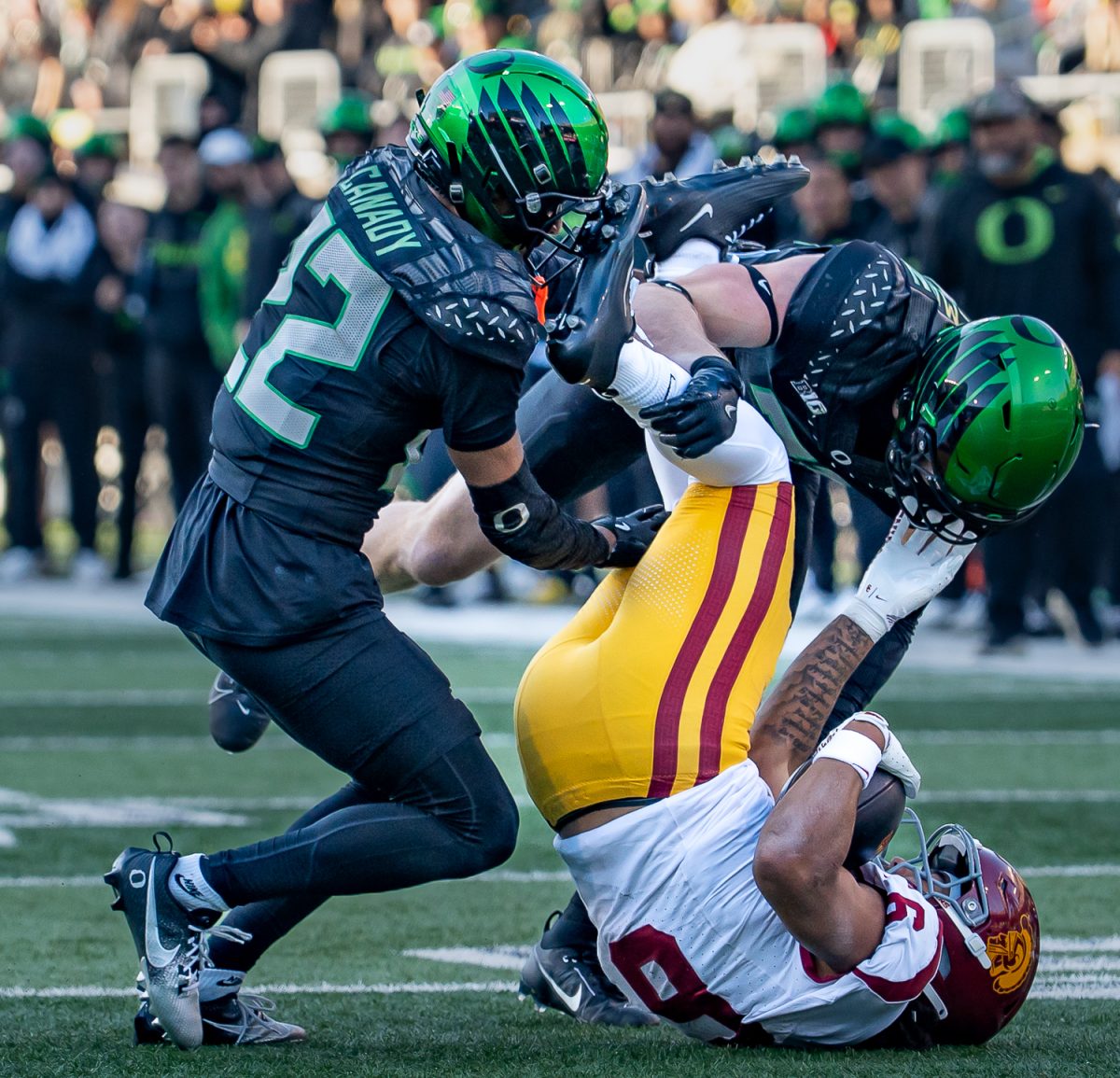 Oregon Ducks linebacker Bryce Boettcher (28) and Oregon defensive back Jadon Canady (22) tackle Southern California Trojans wide receiver Ja'Kobi Lane (8). The No. 7 University of Oregon Ducks take on West Coast rivals, the No. 15 USC Trojans in a game at Autzen Stadium in Eugene, Ore. on Nov. 22, 2025. The Ducks won the game 42-27, with tight end Kenyon Sadiq having six catches for 72 yards and running back Noah Whittington ran for 104 yards. (Saj Sundaram/Emerald)