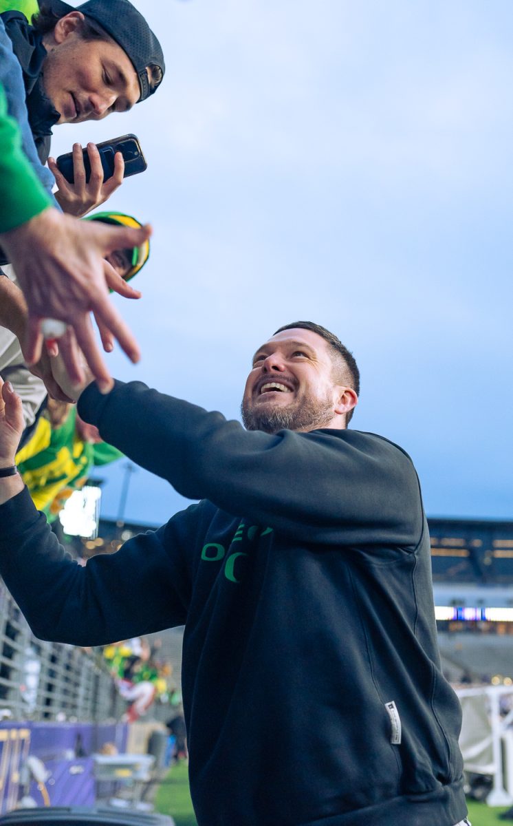 Oregon Ducks head coach Dan Lanning shakes Oregon fans hands after the game ends. The No. 4 University of Oregon Ducks defeated the University of Washington Huskies 26-14 at Husky Stadium in Seattle, Wash. on Nov. 29, 2025, securing a College Football Playoff first round game. (Saj Sundaram/Emerald)
