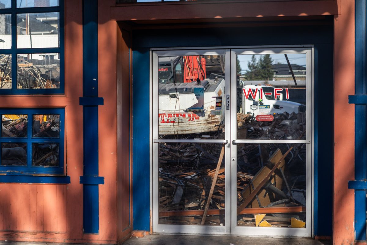 Debris from the demolition of Espresso Roma is visible through the front doors of the café in Eugene, Ore. on Thursday, Dec. 11, 2025. (Max Unkrich/Emerald)