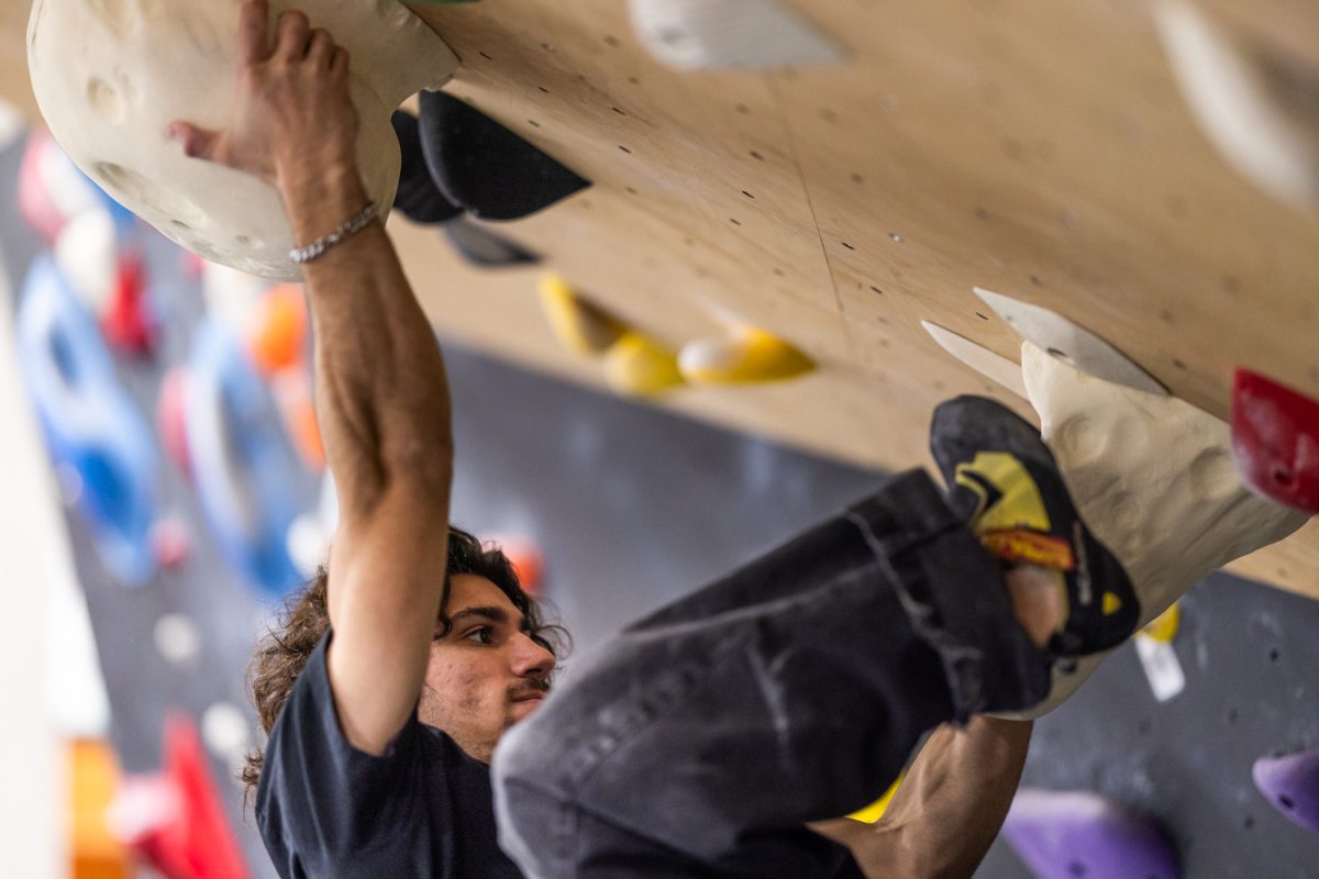 Lucas Cvitanich climbs an overhanging bouldering route at Circuit Bouldering Gym on Wednesday, Dec. 17, in Eugene, Ore. Climbers at the gym regularly train on steep terrain that emphasizes body tension, grip strength and controlled movement. (Max Unkrich/Emerald)