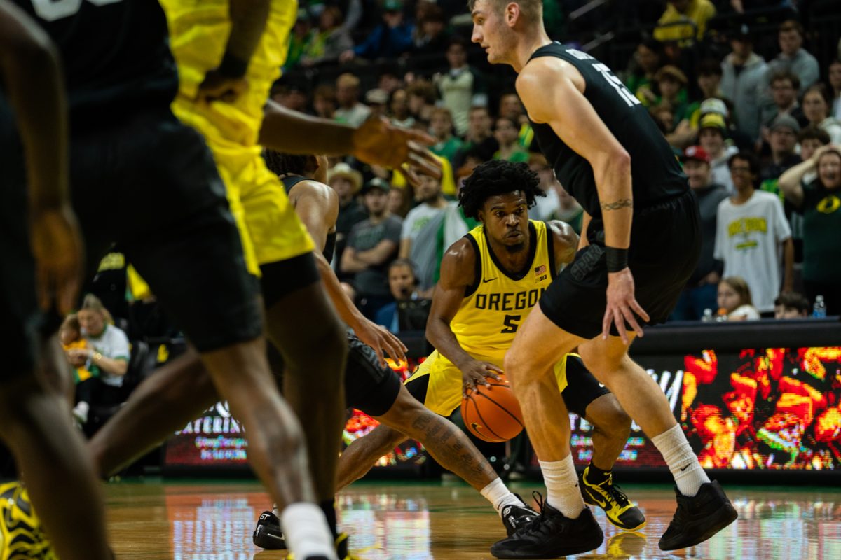 Duck senior guard Takai Simpkins (5) attempts to dribble around spartan defenders. The University of Oregon’s men's basketball team took on Michigan State’s men's basketball team in an intense match on Jan. 20, 2026 at Matthew Knight Arena in Eugene, Ore. (Katie Poluyansky/Emerald)