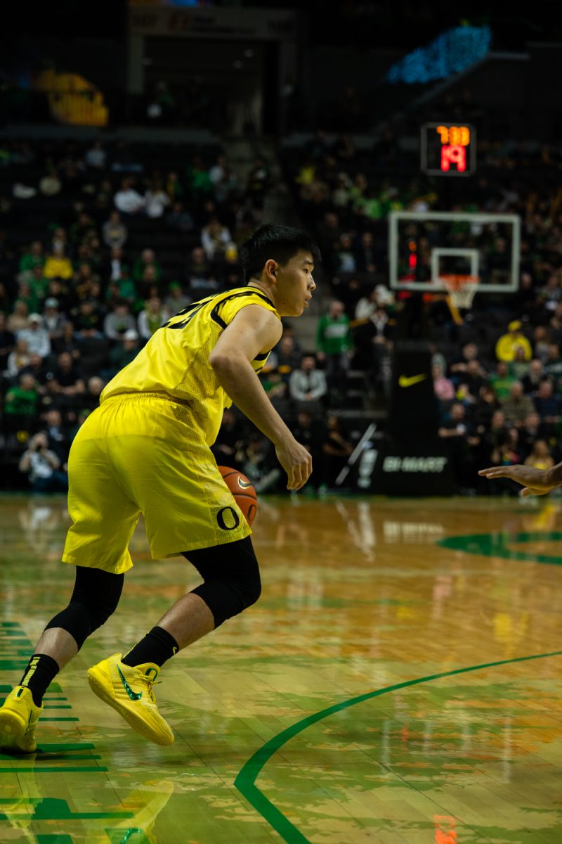 Duck sophomore guard Wei Lin (23) dribbles along the 3-point line and looks to pass to an open player. The University of Oregon’s men's basketball team took on Michigan State’s men's basketball team in an intense match on Jan. 20, 2026 at Matthew Knight Arena in Eugene, Ore. (Katie Poluyansky/Emerald)