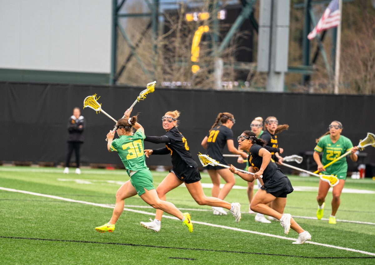 Duck senior midfielder Anna Simmons (30) throws a powerful ball towards the goal while being defended by Sun Devils senior midfielder Claire Beucher (23). On Feb. 7th, 2026 the University of Oregon women's lacrosse team hosted a season-opening game against Arizona State University on Papé Field in Eugene, Ore. (Katie Poluyansky/Emerald)