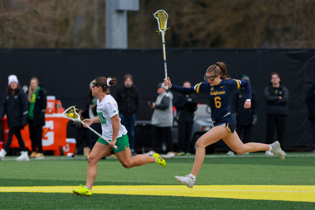 Senior middie for the Ducks, Anna Simmons (30) speeds past her Cal defender Jane Middleton (6). The University of Oregon women’s lacrosse team hosts the California Golden Bears at Pape Field in Eugene, Ore., on Thursday, Feb. 19, 2026, losing 14-9. (Julia Massa/Emerald)