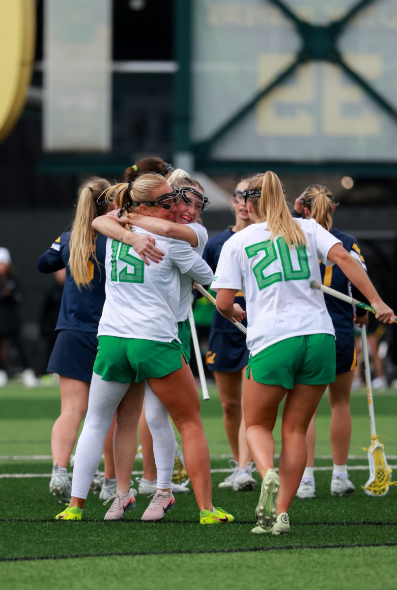 Ducks Avery Young (15) and Rachel Pallo (1) hug after a goal by Pallo. The University of Oregon women’s lacrosse team hosts the California Golden Bears at Pape Field in Eugene, Ore., on Thursday, Feb. 19, 2026, losing 14-9. (Julia Massa/Emerald)