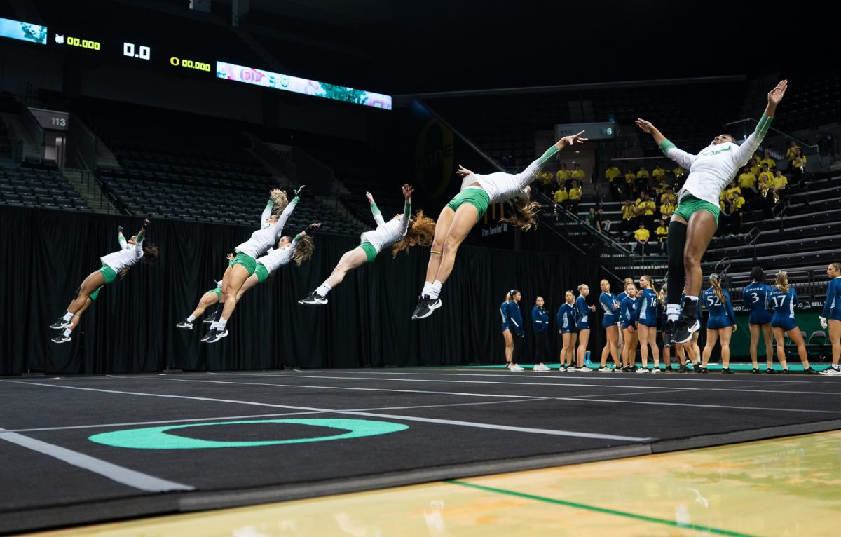 Members of the Oregon Acro and Tumbling team flip through the air across the mat during the acro event. The Oregon Acro and Tumbling team takes on Quinnipiac University at Matthew Knight Arena in Eugene, Ore. on Feb 21, 2025. (Saj Sundaram/Emerald)