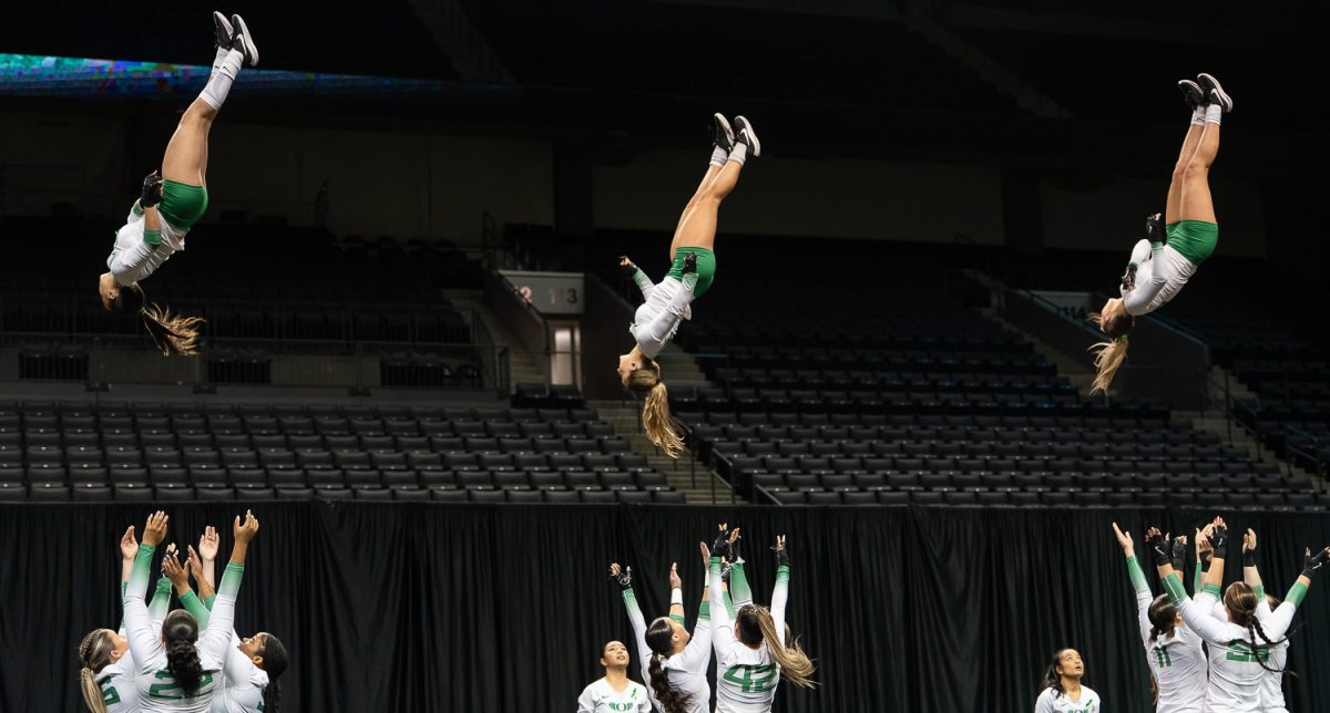 Top/tumbler Mari Fukutomi (7), top/tumbler Logan Davis (44) and top/tumbler Carly Garcia (36) are tossed in the air, spinning as they come back down. The Oregon Acro and Tumbling team took on the No. 3 Quinnipiac University at Matthew Knight Arena in Eugene, Ore. on Feb 21, 2025, winning 270.640 to 265.425. (Saj Sundaram/Emerald)