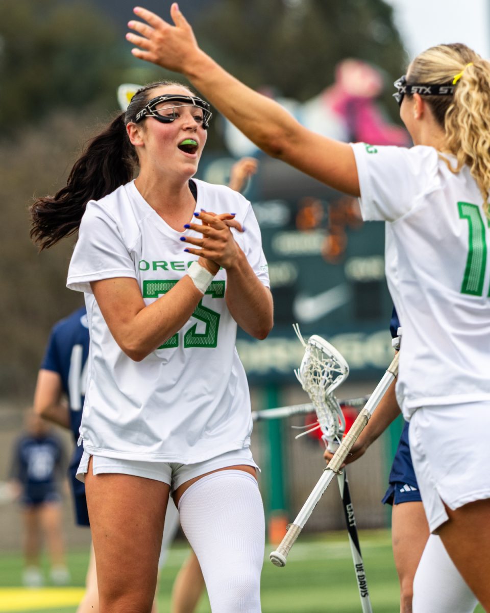 Oregon attacker Lyla Hurley (25) claps with teammate Gabby Santucci (12) after a goal in the second period. The Oregon Ducks women’s lacrosse hosted the UC Davis Aggies at Pape Field in Eugene, Ore. on Feb. 28, 2026, winning 10-9. (Owen Burriss/Emerald)
