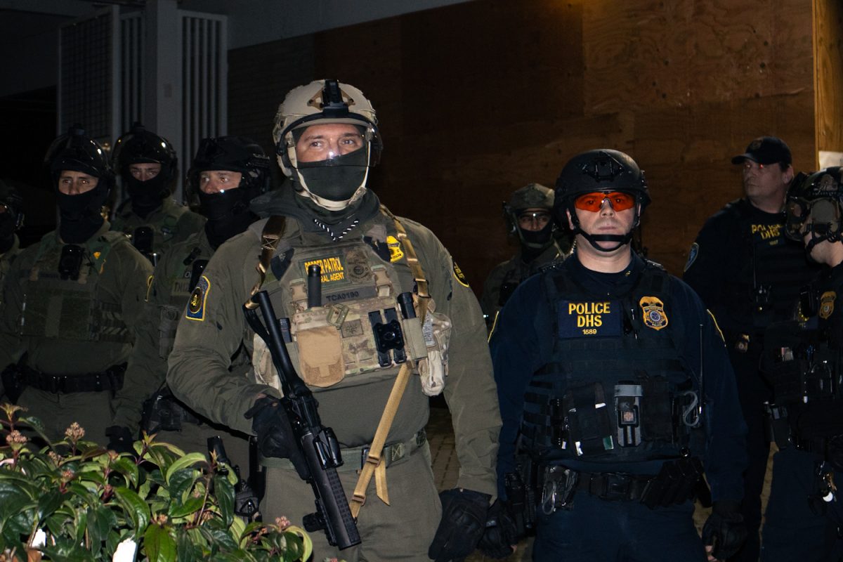 ICE officers stand outside Macadam Ave. facility in Portland. (Mikayla Mesko/Emerald)