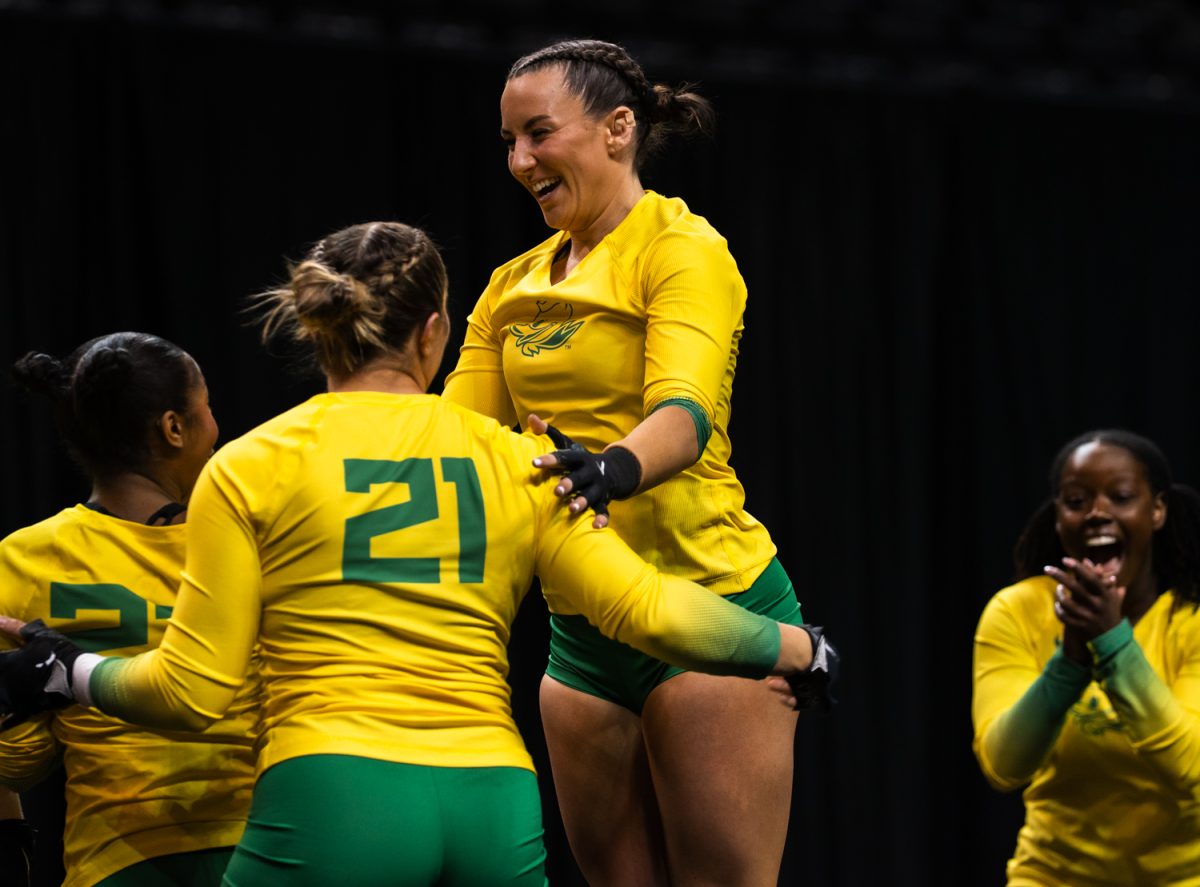 Duck junior tumbler Ashlyn Parlett (11) celebrates with her teammates after the end of their performance. On March 15,2026 the University of Oregon Ducks Women’s Acrobatics and Tumbling team beat the Gaels in a tight home meet against Iona University at Matthew Knight Arena in Eugene, Ore. (Katie Poluyansky/Emerald).