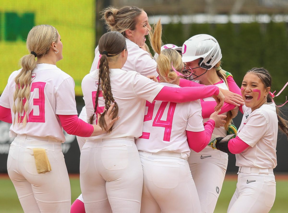 Oregon catcher Emma Cox (21) is embraced by teammates after a walk off sacrifice fly ball into right field. Oregon Ducks Softball take on the Penn State Nittany Lions at Jane Sanders Stadium in Eugene, Ore., on Mar. 15, 2026. (Tyler Graham/Emerald)
