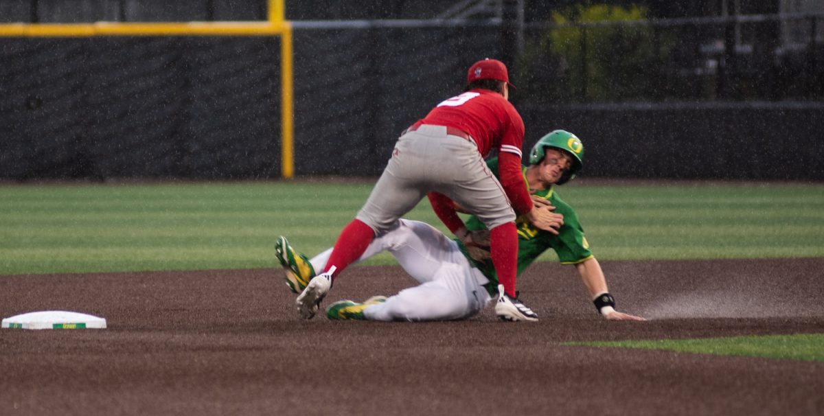 Oregon outfielder Angel Laya (53) is tagged out by Nebraska infielder Rhett Stokes (9) as he slides through mud and rain to third base. No. 21 Oregon baseball takes on No. 19 Nebraska on April 10th, 2026, at PK Park, in Eugene, Ore. (Chris Castro/Emerald)