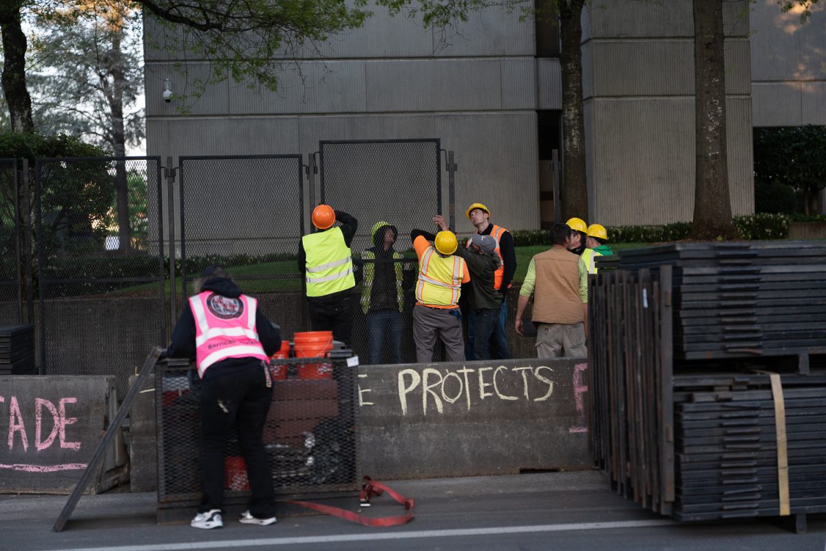 Construction workers start to place the fence around the Eugene Federal Building. On April 29, 2026, protesters gathered at the Eugene Federal Building in Eugene, Ore. to object to the building of a fence around the building federal agents of the Department of Homeland Security's Federal Protective Services stood guard. (Saj Sundaram/Emerald)