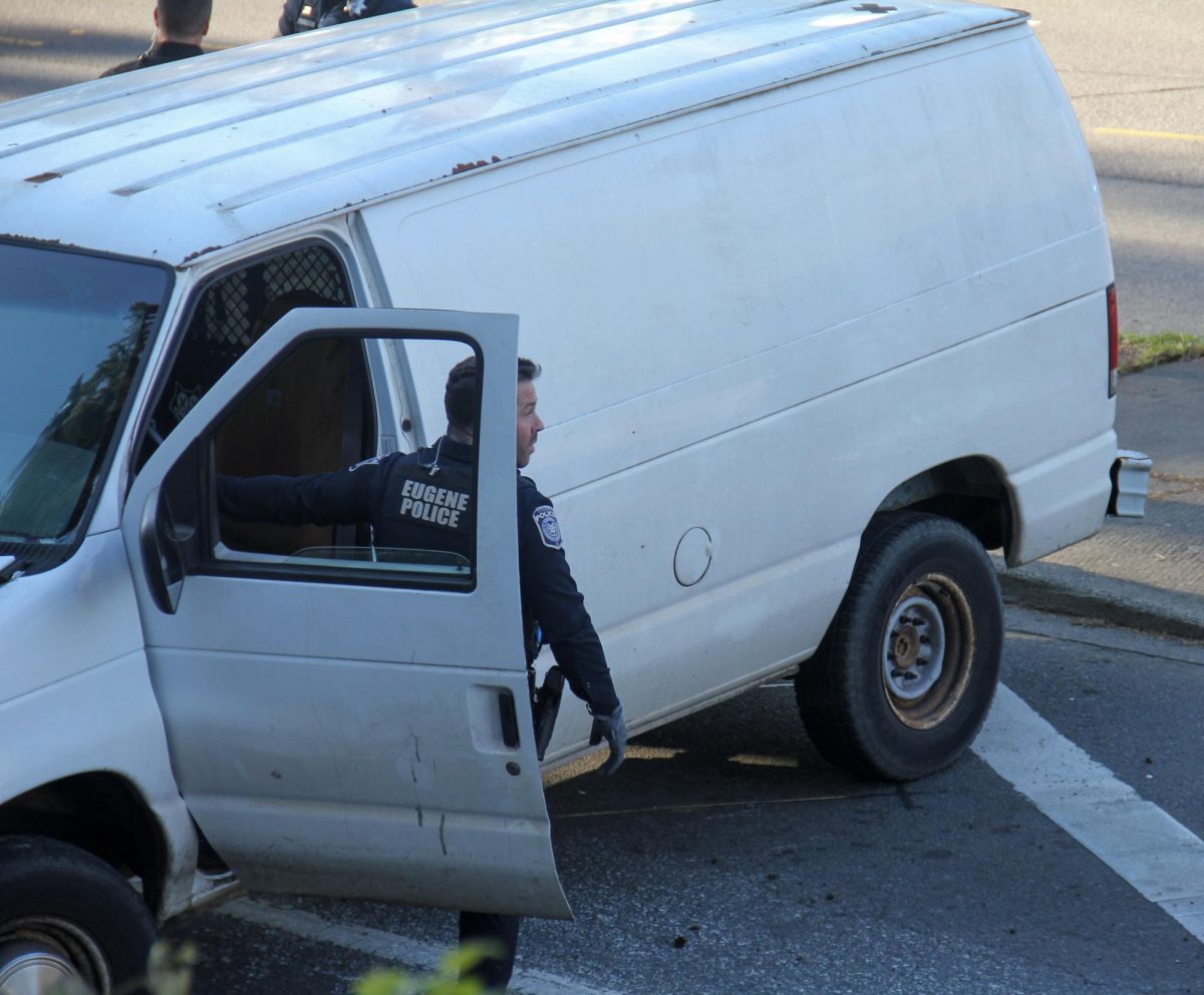 Eugene police officers inspect a damaged van at the intersection of East 11th Avenue and Franklin Boulevard in Eugene, Ore., following a crash that closed nearby roads on Friday, April 3, 2026. Tarek Anthony/Emerald