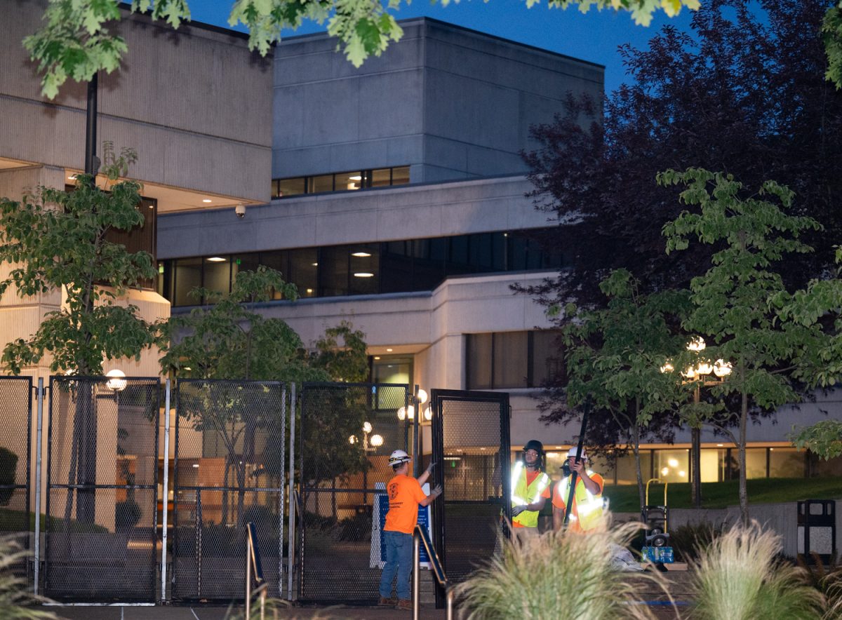 A fence surrounding the Federal Building in Eugene, Ore., is removed on July 1, 2026. The fence, which had been erected on the property after a series of protests, was ordered to be removed by a judge after it was found to violate the First Amendment rights of people wishing to assemble there. (Chris Castro/Emerald)