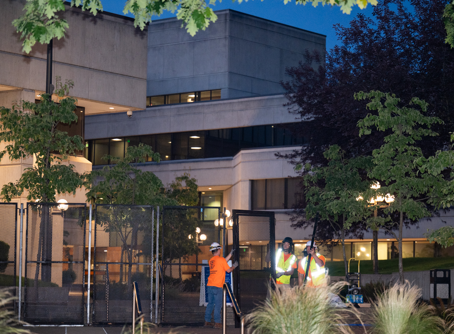 A fence surrounding the Federal Building in Eugene, Ore., is removed on July 1, 2026. The fence, which had been erected on the property after a series of protests, was ordered to be removed by a judge after it was found to violate the First Amendment rights of people wishing to assemble there. (Chris Castro/Emerald)